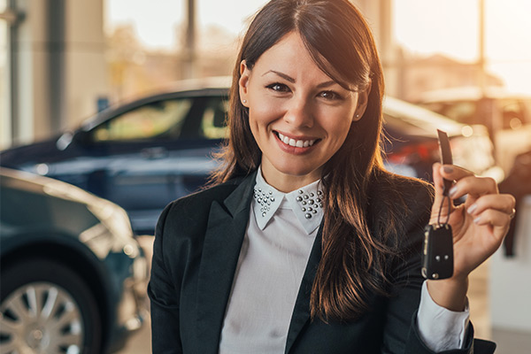 Cheerful young woman showing her new car key at Fuccilloship.